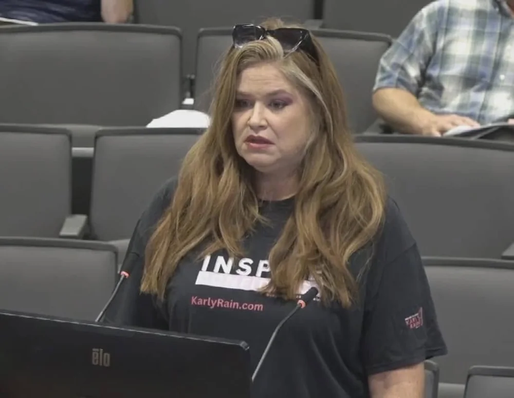 Amber Wood wearing a KarlyRain.com shirt speaking at a county board meeting.
